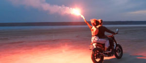 couple of a motorbike holding a flare