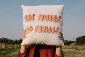 the future is female printed on a cushion held up by a woman
